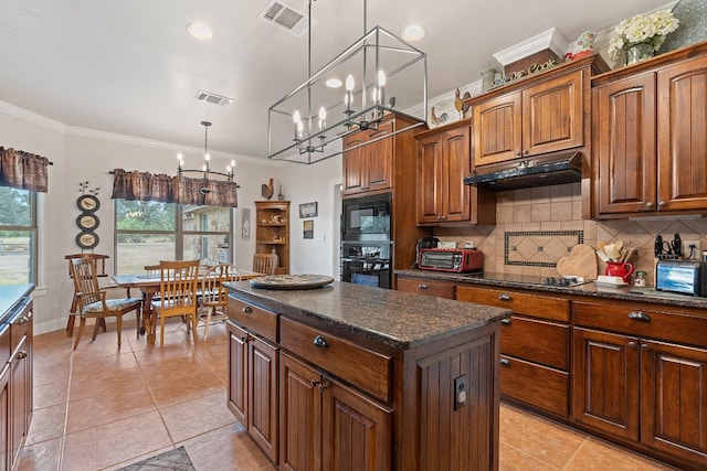 kitchen featuring a center island, crown molding, black appliances, a notable chandelier, and decorative light fixtures