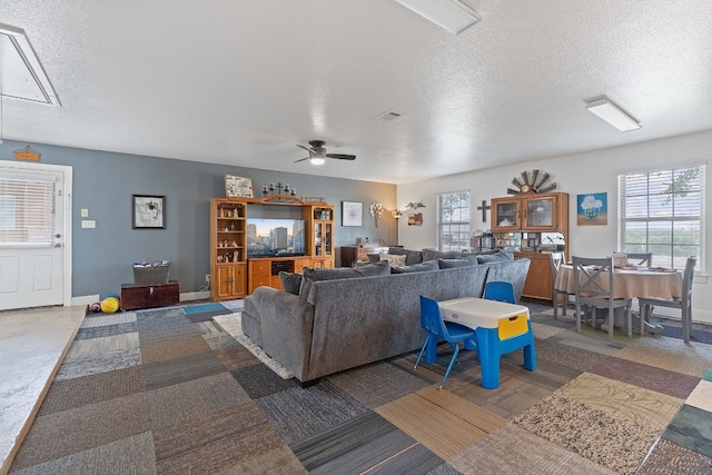 carpeted living room with a textured ceiling and ceiling fan