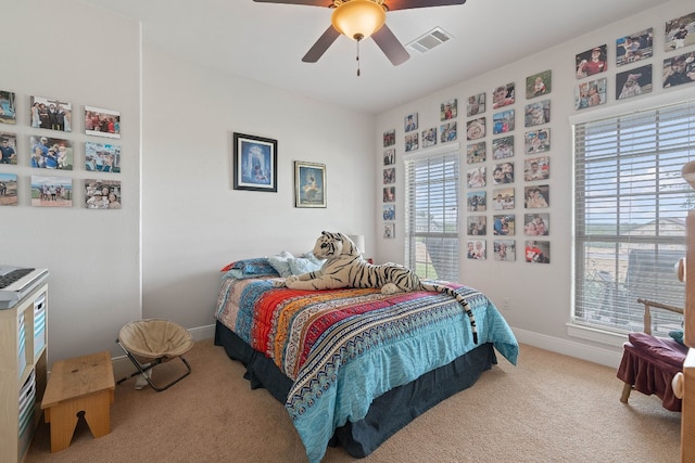 bedroom featuring ceiling fan, carpet flooring, and multiple windows