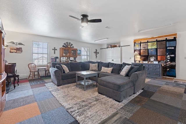 living room with a textured ceiling, plenty of natural light, and ceiling fan