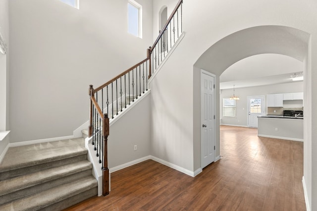 stairway featuring hardwood / wood-style floors and an inviting chandelier