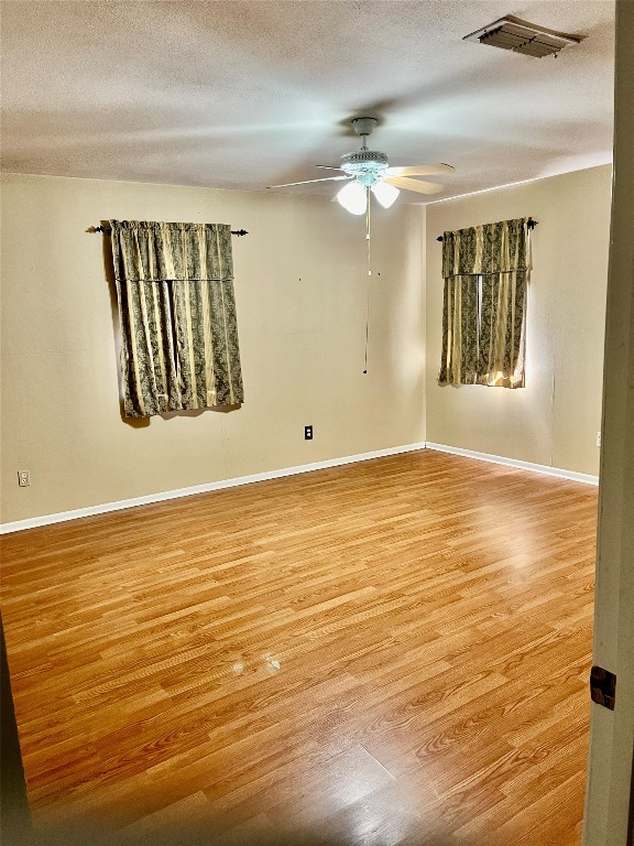 spare room with light hardwood / wood-style flooring, a textured ceiling, and ceiling fan