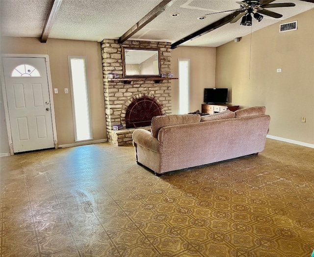 living room with a brick fireplace, a textured ceiling, beam ceiling, and ceiling fan