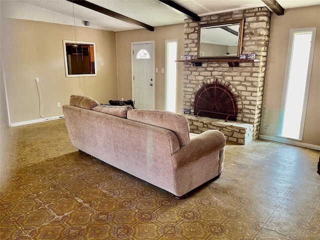 living room featuring a textured ceiling, beam ceiling, and a fireplace