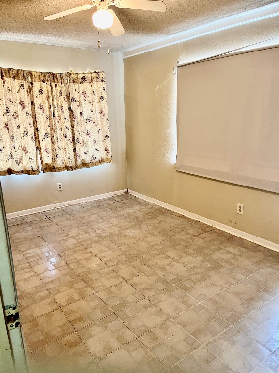 spare room with a textured ceiling and ceiling fan