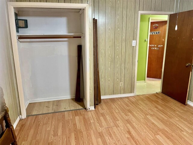 1133 W Bell St, Bartlett, TX 76511 - unfurnished bedroom featuring baseboards, wood walls, and wood finished floors