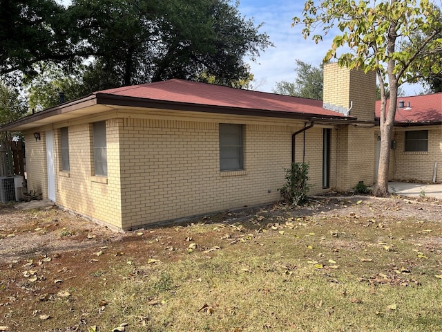 exterior space with central AC and a yard