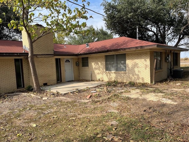 1133 W Bell St, Bartlett, TX 76511 - back of house with brick siding, a patio, a chimney, and central air condition unit