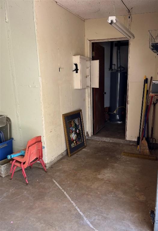 1133 W Bell St, Bartlett, TX 76511 - hall with unfinished concrete flooring and water heater