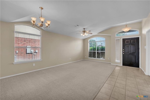 entrance foyer with ceiling fan with notable chandelier, vaulted ceiling, and light tile patterned floors