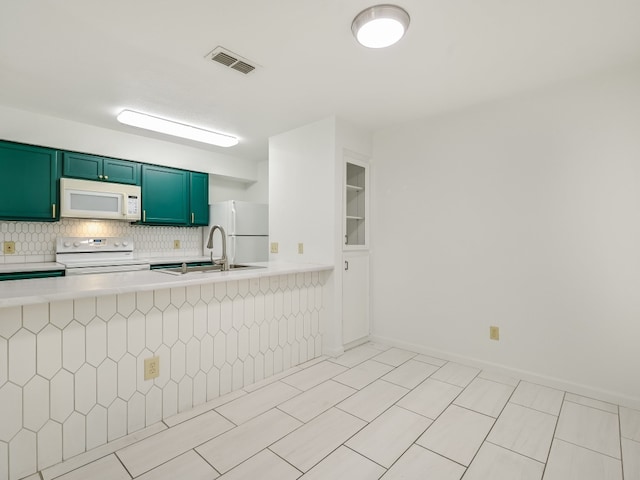 kitchen featuring backsplash, sink, kitchen peninsula, and white appliances