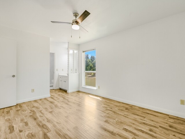 unfurnished bedroom featuring connected bathroom, ceiling fan, and light wood-type flooring