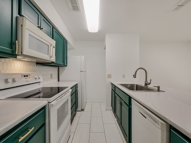 kitchen featuring white appliances, sink, green cabinetry, decorative backsplash, and light tile patterned floors