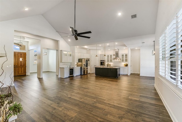 unfurnished living room with ceiling fan, high vaulted ceiling, dark hardwood / wood-style floors, wine cooler, and a healthy amount of sunlight