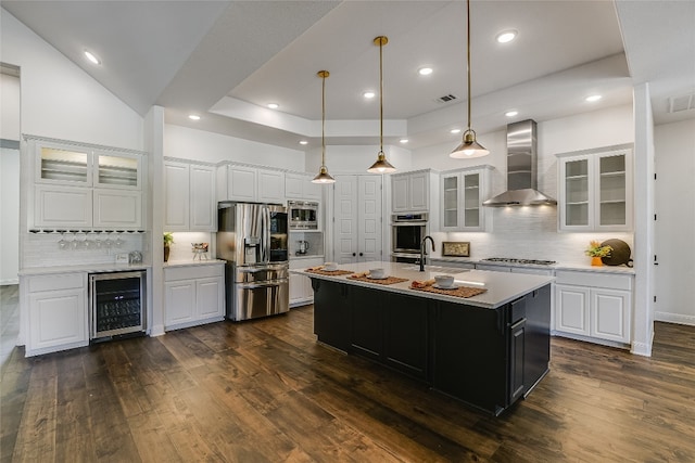 kitchen featuring wall chimney exhaust hood, appliances with stainless steel finishes, wine cooler, and white cabinets