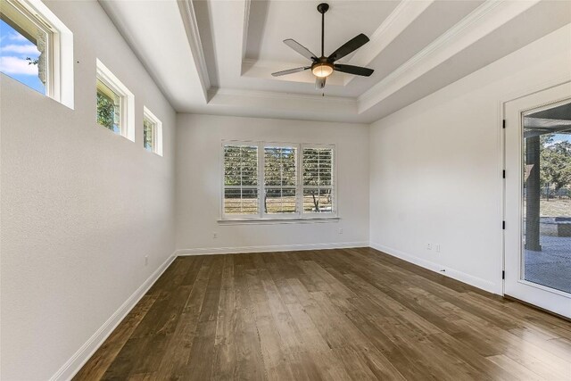 empty room with ornamental molding, ceiling fan, dark hardwood / wood-style floors, and a raised ceiling