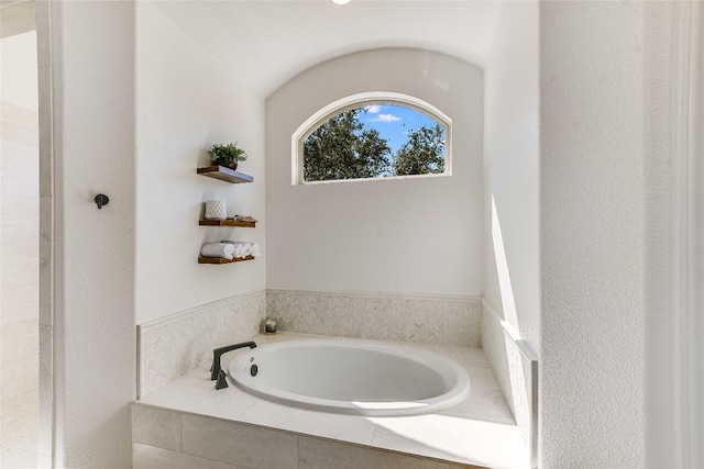 bathroom featuring a relaxing tiled tub