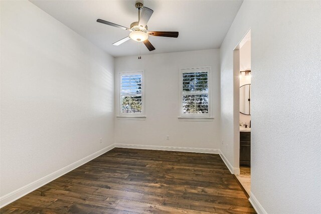 spare room with dark wood-type flooring and ceiling fan