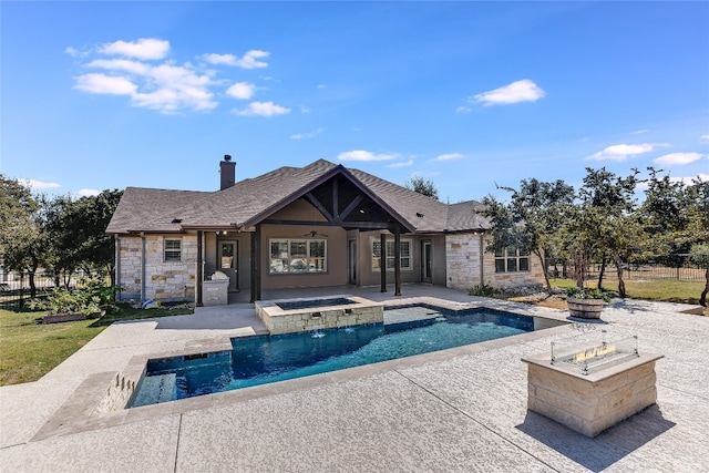 view of pool with an outdoor fire pit, a patio area, pool water feature, and an in ground hot tub