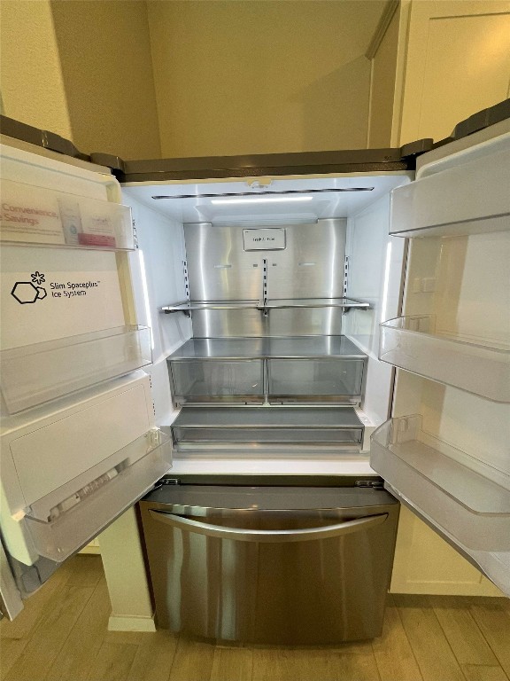 interior details featuring stainless steel refrigerator and light hardwood / wood-style floors