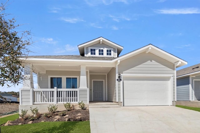 204 Lavender Ln, Elgin, TX 78621 - view of front of home with driveway, a porch, an attached garage, and roof with shingles