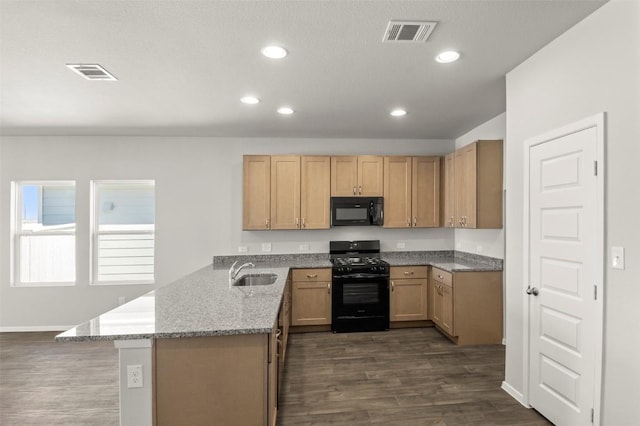 204 Lavender Ln, Elgin, TX 78621 - kitchen with black appliances, a peninsula, recessed lighting, dark wood-type flooring, and light stone countertops