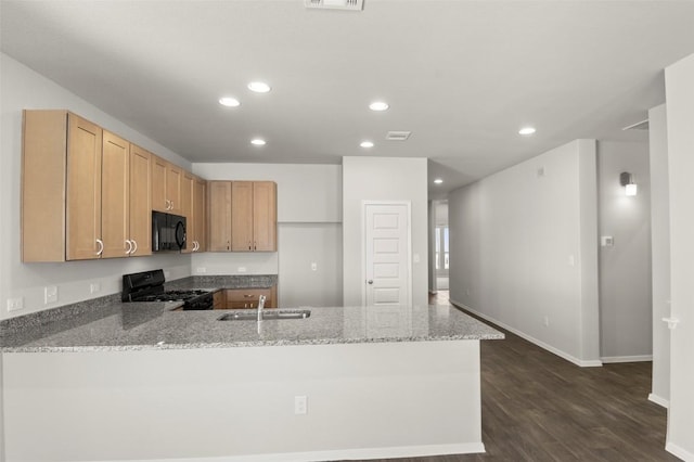 204 Lavender Ln, Elgin, TX 78621 - kitchen with black appliances, a peninsula, light stone counters, recessed lighting, and dark wood-style floors