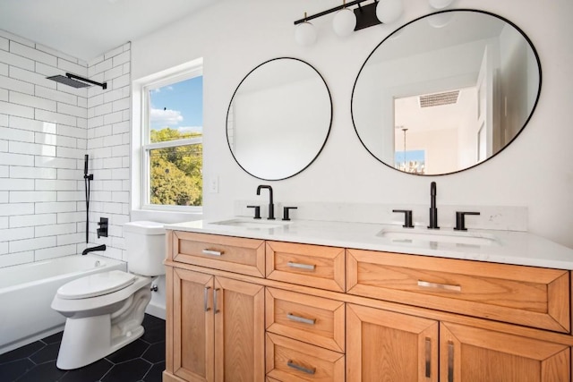 full bathroom featuring tiled shower / bath, vanity, toilet, and tile patterned flooring