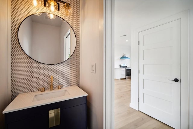 bathroom with tasteful backsplash, vanity, and hardwood / wood-style floors