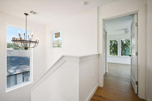 hallway featuring wood-type flooring and a chandelier