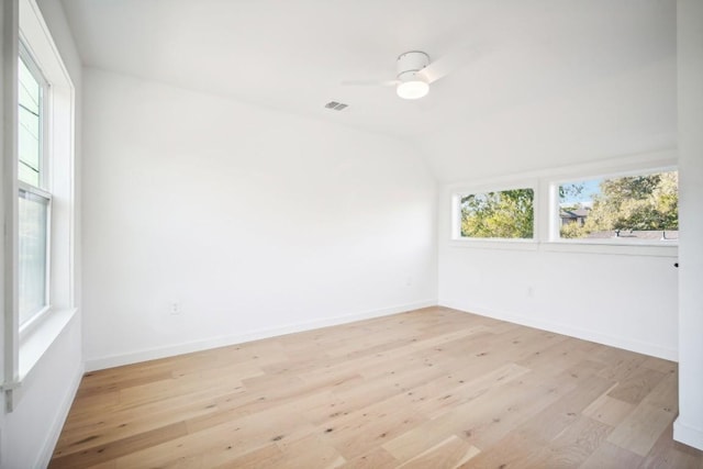 empty room featuring ceiling fan, vaulted ceiling, and light wood-type flooring