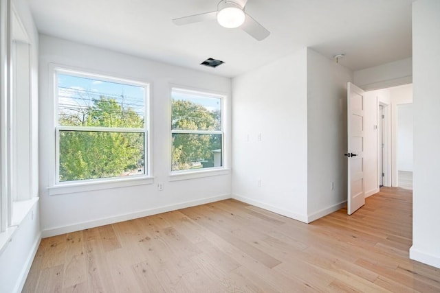 empty room featuring ceiling fan, plenty of natural light, and light hardwood / wood-style floors