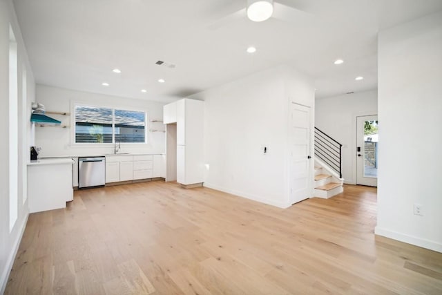 unfurnished living room featuring sink and light hardwood / wood-style flooring