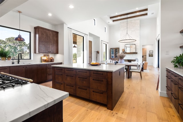 kitchen with beam ceiling, a center island, and pendant lighting