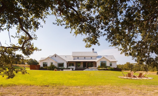 back of property with a lawn, an outdoor fire pit, and a patio