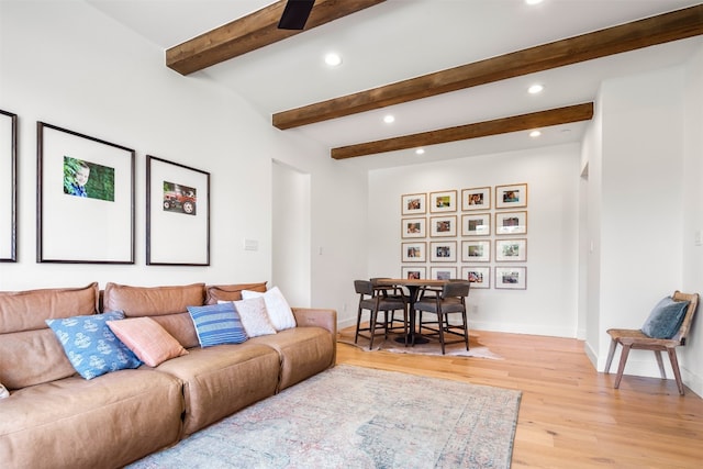 living room featuring beamed ceiling and light wood-type flooring