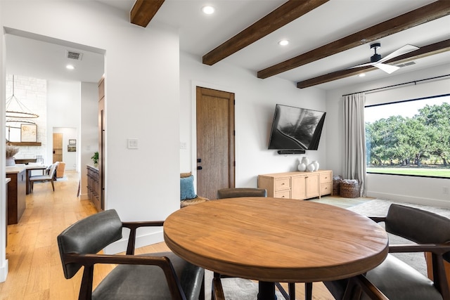 dining area featuring beamed ceiling, light hardwood / wood-style flooring, and ceiling fan