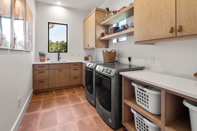 laundry area with sink, light tile patterned floors, cabinets, and independent washer and dryer