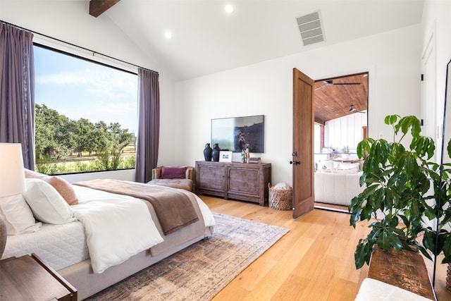 bedroom featuring vaulted ceiling with beams and light wood-type flooring