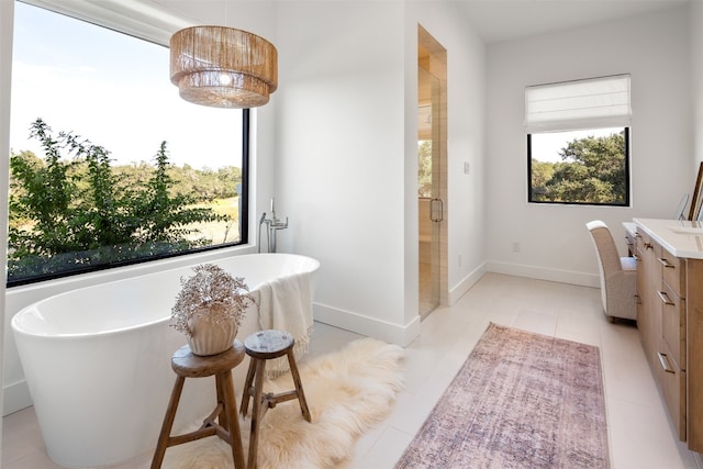 bathroom with tile patterned flooring, plenty of natural light, vanity, and independent shower and bath