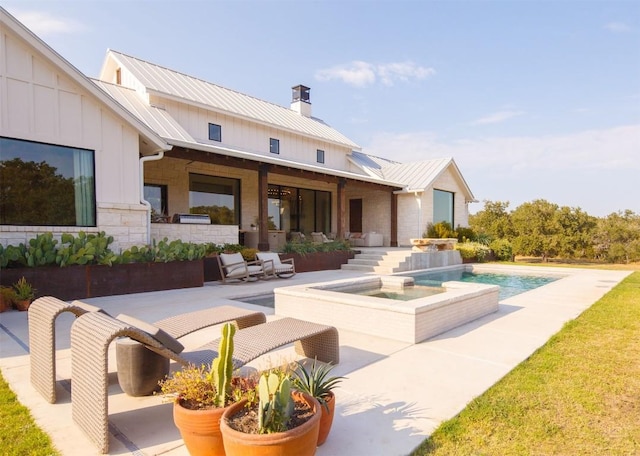 rear view of property featuring a swimming pool with hot tub and a patio