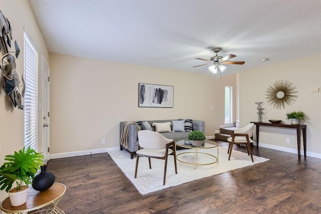 living room featuring a textured ceiling, dark hardwood / wood-style floors, ceiling fan, and a healthy amount of sunlight