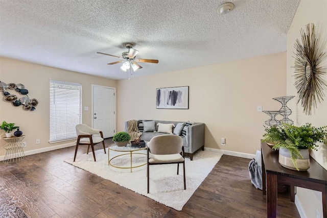 living room with ceiling fan, dark hardwood / wood-style flooring, and a textured ceiling