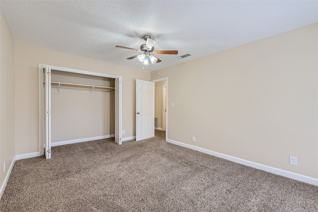 unfurnished bedroom featuring carpet, a textured ceiling, a closet, and ceiling fan