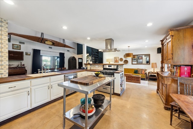 kitchen featuring kitchen peninsula, island exhaust hood, appliances with stainless steel finishes, decorative light fixtures, and sink