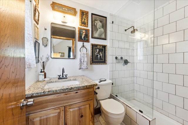 bathroom featuring toilet, vanity, and a tile shower