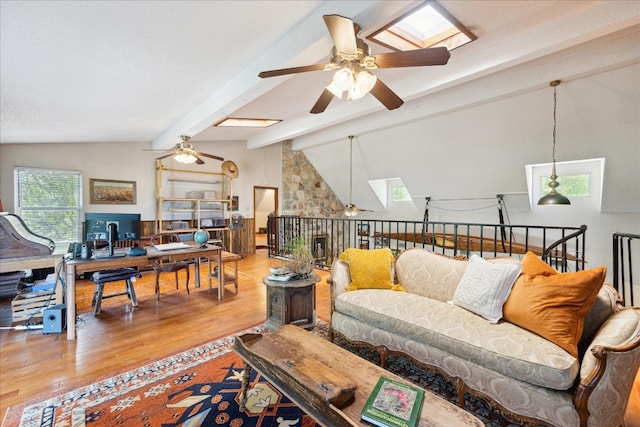 living room with lofted ceiling with skylight, hardwood / wood-style flooring, and ceiling fan