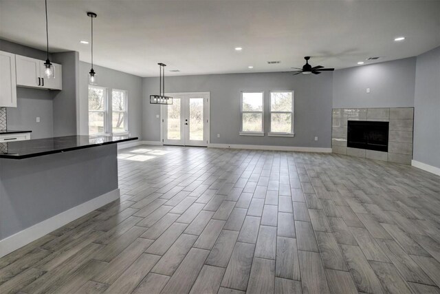 unfurnished living room featuring a fireplace, light wood-type flooring, and ceiling fan