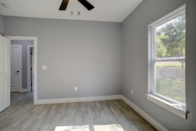 empty room with ceiling fan and light hardwood / wood-style flooring