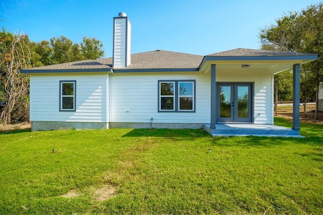 rear view of property with french doors, a patio, and a lawn